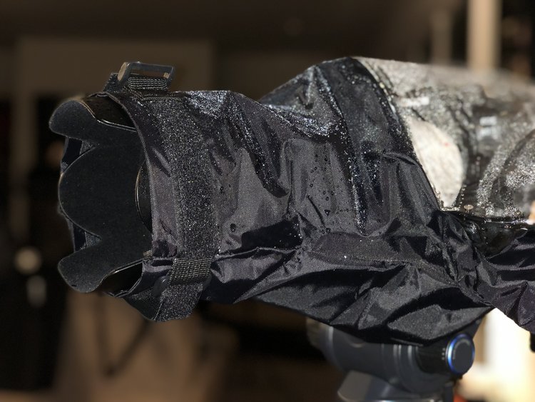 The dslr rain cover grips the end of the lens using grippy material and a velcro strap.