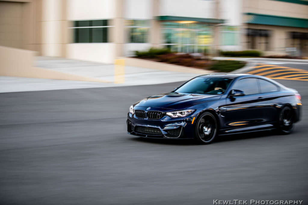 Slow camera shutter speed used to photograph a moving car, resulting in a crisp view of the car with the background is blurred, creating a sense of motion.