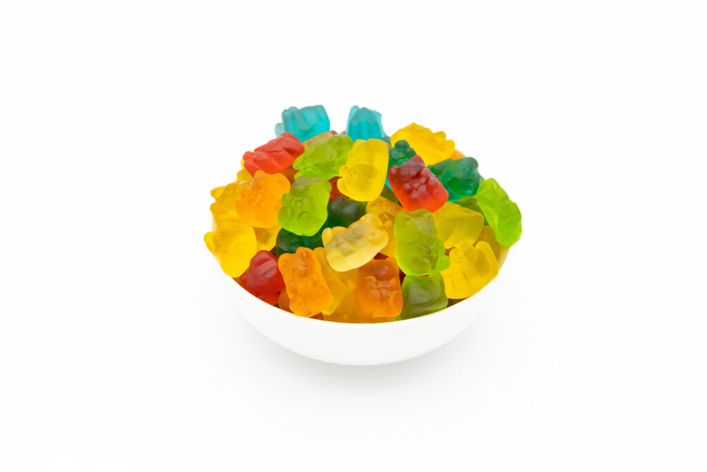 Simplified photo of a small bowl of Gummy Bears on a white background with no visual distractions.