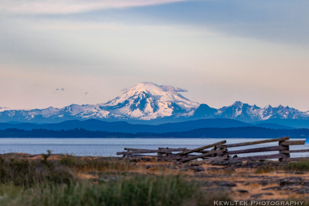 Landscape photo of distant mountains, with Mt. Baker, the point of focus, prominently located in the center of the frame.
