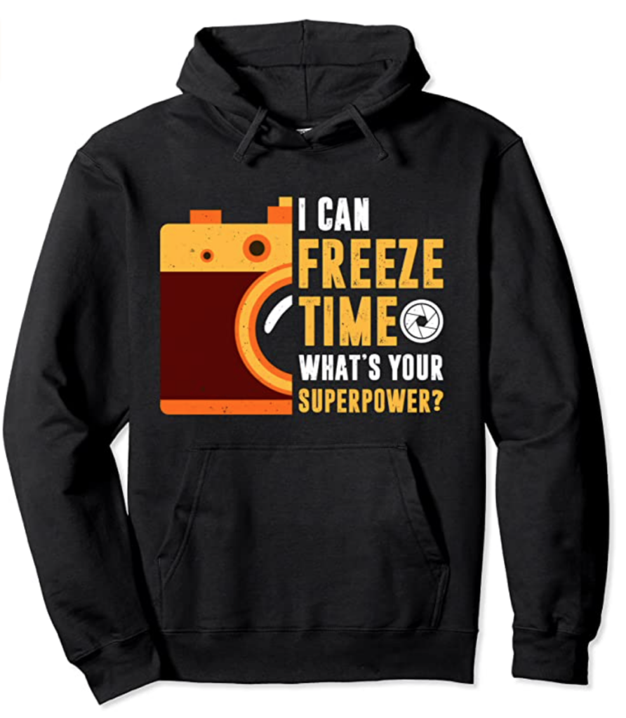 Image of a hoodie with an image of a camera printed on it, as well as the phrase, "I can freeze time, what's your super power?"