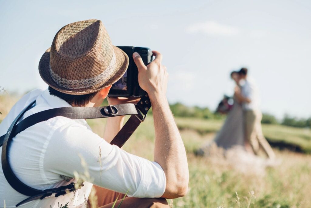 Image of a photographer practicing photography composition techniques as he takes a picture of people in the distance