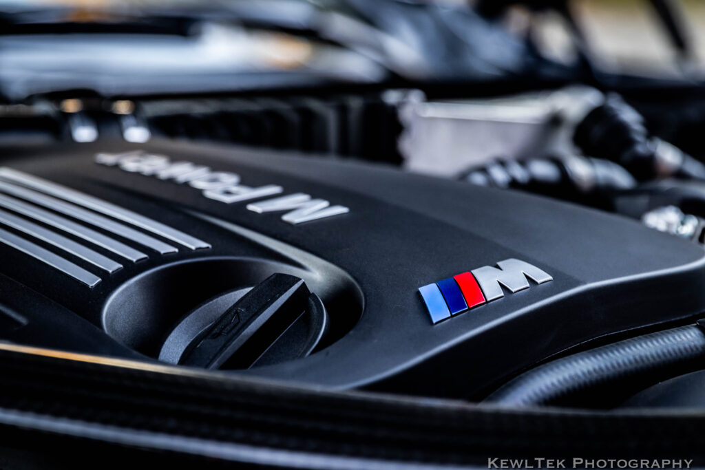 Closeup shot of a car badge in an engine compartment of a sports car.