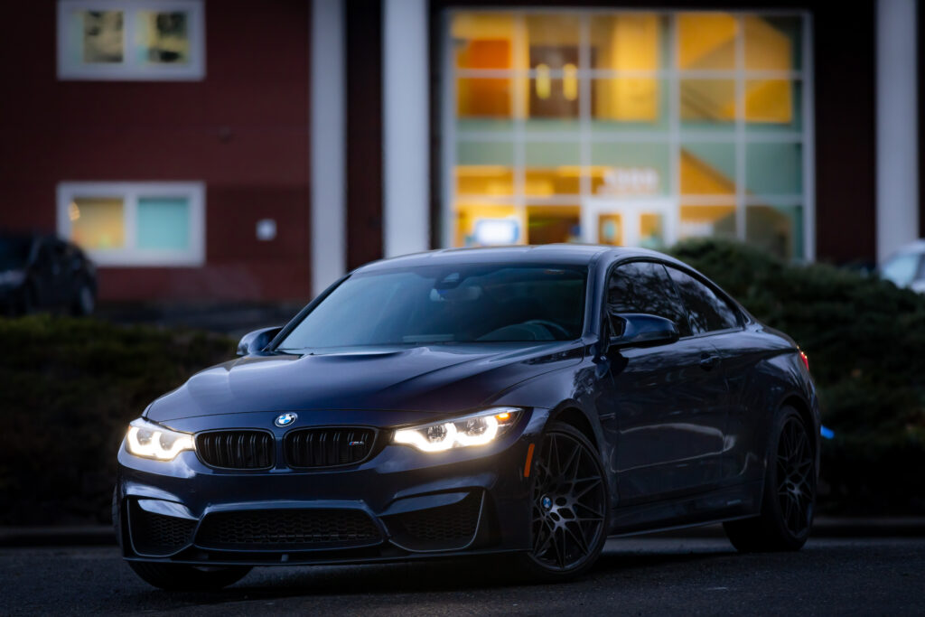 Image of a sports car in front of an office building at twilight, zoomed in to demonstrate how zoom compression causes the building to appear much closer to the car.