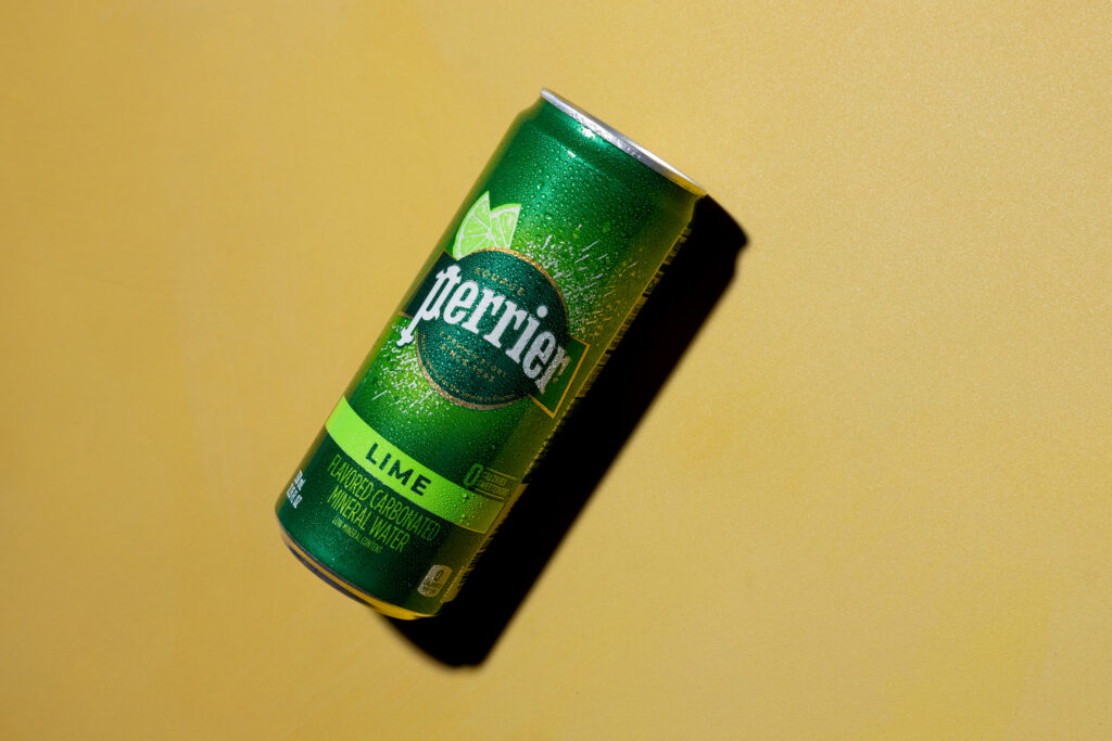 Behind the scenes Perrier drink can on plain background