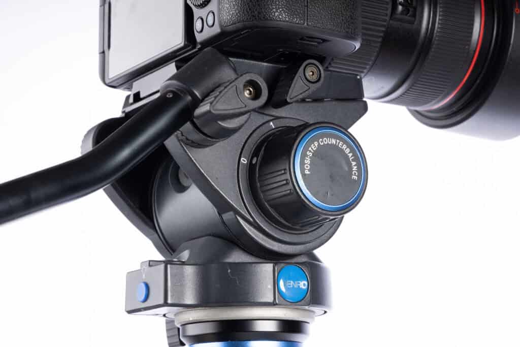 Close-up of a Benro S6 PRO fluid video head mounted on a tripod, showing the pan and tilt controls and counterbalance dial.