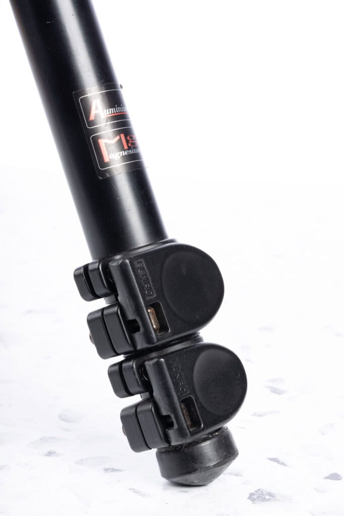Close-up of a tripod leg showing its dual flip-lock mechanisms used for quickly extending and securing the leg sections.