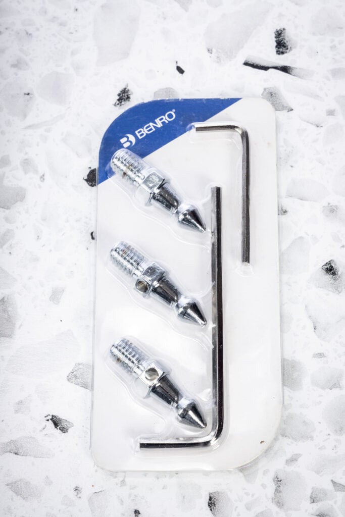 Set of interchangeable Benro spiked tripod feet arranged neatly in their included package, designed for added stability on dirt, gravel, or uneven outdoor surfaces.