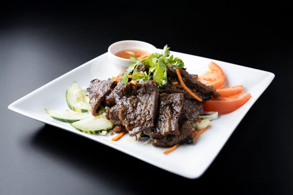beef dish photographed with one softbox light and white foam board showing bright color and clean shadows on a black surface.