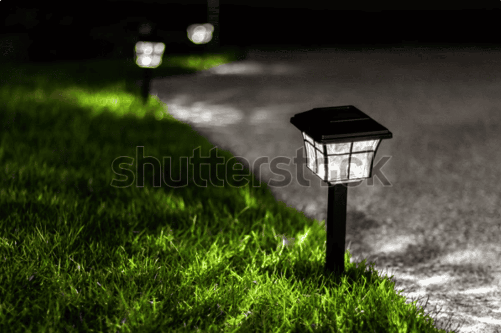 Solar garden path lights illuminating a driveway at night, photographed as a stock image example